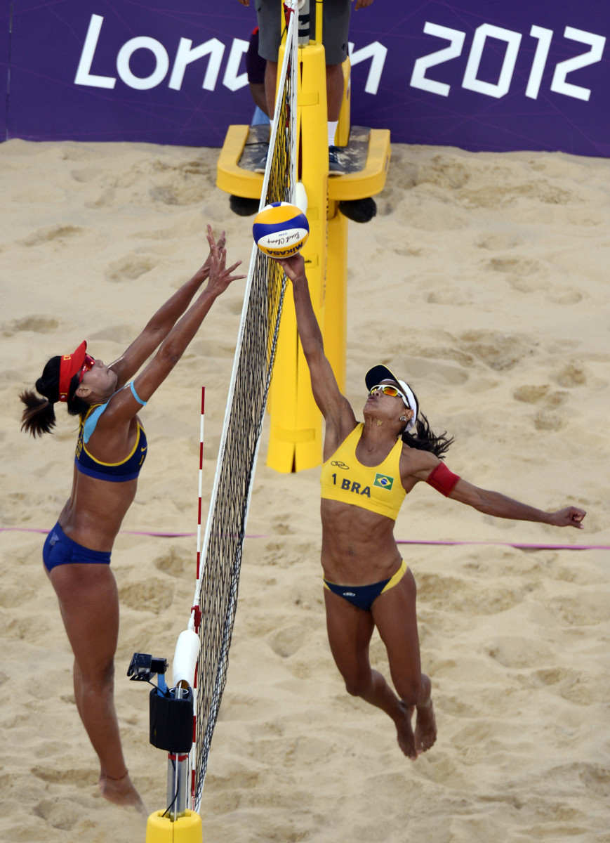 Brazil's Juliana Silva taps the ball over the net as China's Chen Xue tries to block. 