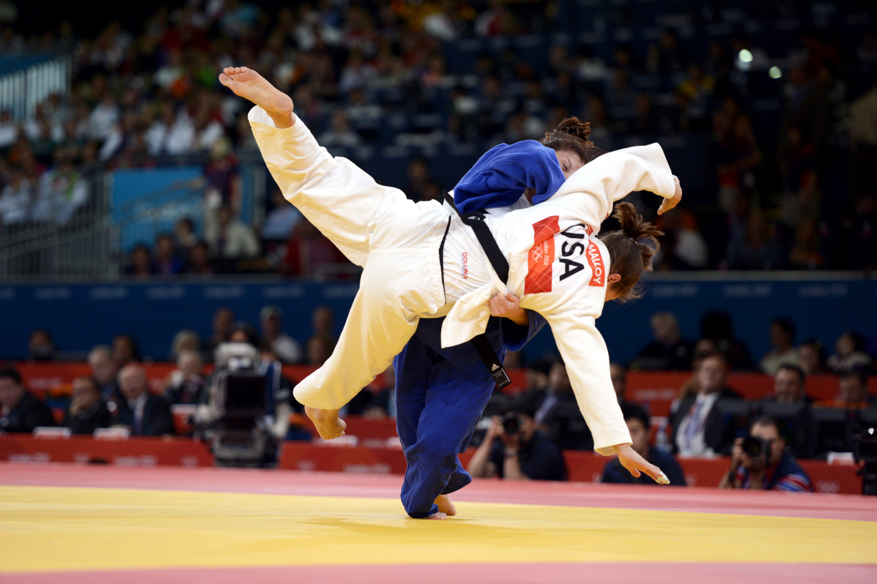 Corina Caprioriu of Romania, the eventual gold medalist, wearing blue, takes down Marti Malloy of the United States during the women's 57kg Judo competition.   Malloy won the bronze medal which she shared with Automne Pavia of France. : London Olympics : Photography by Adam Stoltman: Sports Photography, The Arts, Portraiture, Travel, Photojournalism and Fine Art in New York