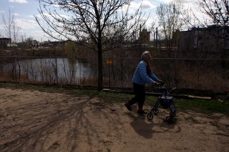 A resident strolls in the Community Peace Garden administered by Korean Social Service Center near the Riverside Plaza Complex in Minneapolis, where many Korean
elders live. The garden provides access to the outdoors, nature, and exercise. Physicians working with the Center report a health benefit from time spent in the garden.