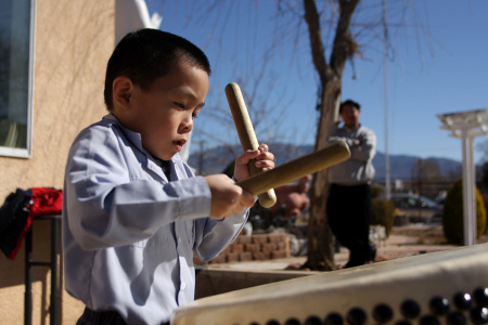 A young boy practices his drumming following youth services at the Van Hanh Buddhist Center in Albuquerque. 
