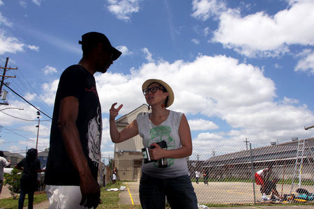 M.K. Nguyen, Deputy Director of VAYLA assists in the taking back and restoration of a park in Central City, New Orleans.  Within hours, a diverse coalition of community members painted new lines on what had been a basketball court, trees were planted, a new backboard installed and a new chain link fence put up, thus making the playground area usable once more.  
