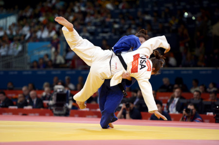 Corina Caprioriu of Romania, the eventual gold medalist, wearing blue, takes down Marti Malloy of the United States during the women's 57kg Judo competition.   Malloy won the bronze medal which she shared with Automne Pavia of France.